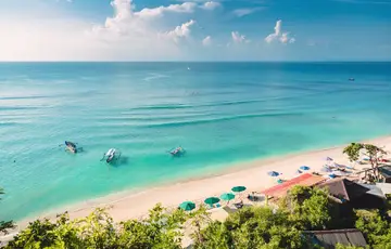 A beach with turquoise water and palm trees